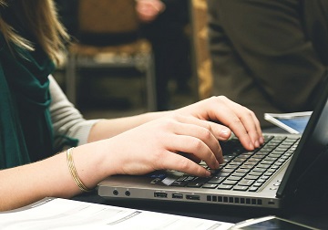 Händer som skriver på tangentbordet på en bärbar dator